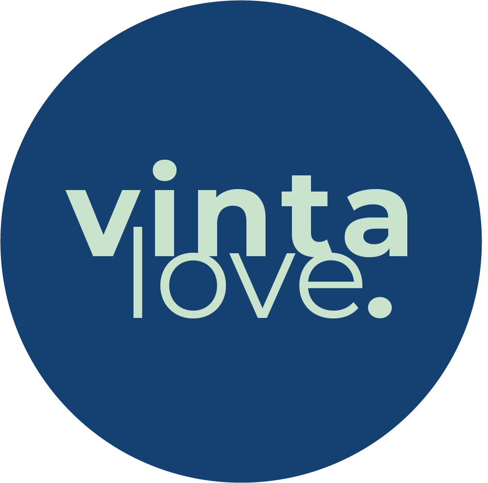 Logo Vinta Love: duży granatowy okrąg z napisem "vintalove" w środku, zapisanym jasnooliwkową czcionką. Słowo "vinta" jest nad słowem "love.", a pionowa linia oddziela "a" i "l" na dwóch poziomach tekstu.